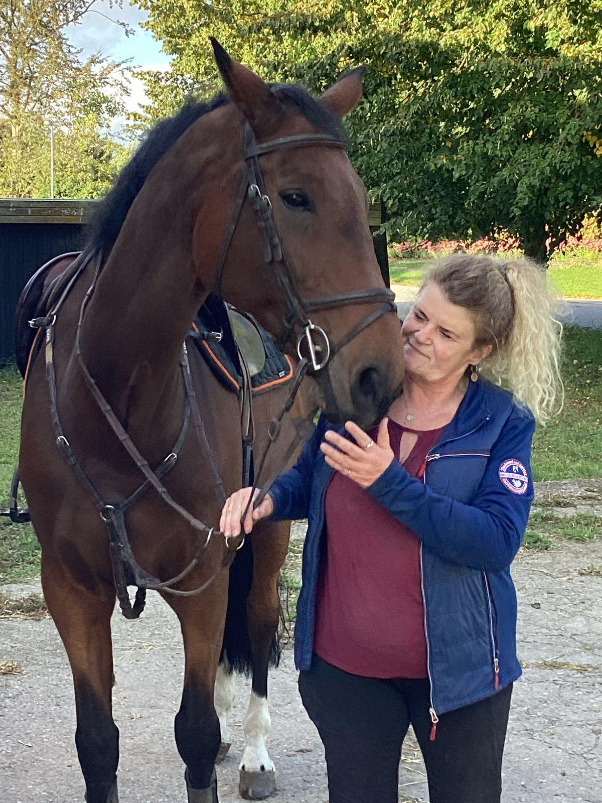 Charlotte Weis, founder of Braveplants, standing with her horse